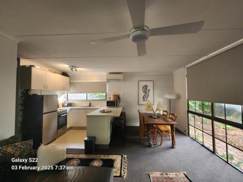 a kitchen and dining room with a ceiling fan at Corindi Beach Pad in Arrawarra