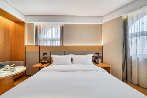 Ένα ή περισσότερα κρεβάτια σε δωμάτιο στο JI Hotel Shanghai Fengxian Situan Powerlong Plaza