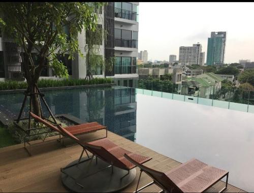 a couple of chairs sitting on top of a building at Modern Bangkok Apartment Train Access in Bangkok