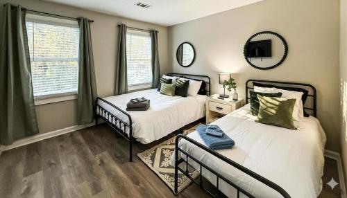 ein Schlafzimmer mit zwei Betten und einem Spiegel in der Unterkunft King Bed Soaking tub, Yard with Screen Patio, Near ATL in Tucker
