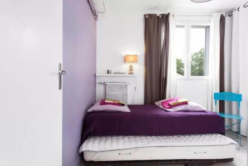 - une chambre avec un lit violet et une fenêtre dans l'établissement Le Clos Des Nobles, à Toulouse