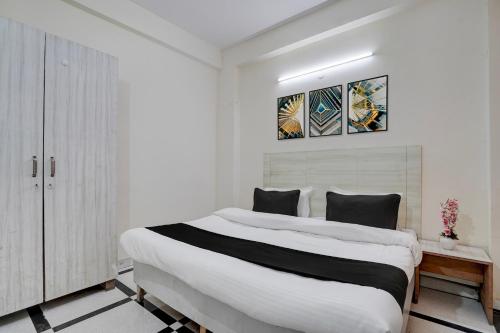 a white bedroom with a large white bed in it at Super Hotel O DLF Phase 1 Metro Station Gurugram in Gurgaon