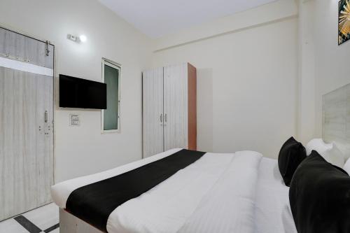 1 dormitorio blanco con 1 cama y TV en la pared en Super Hotel O DLF Phase 1 Metro Station Gurugram, en Gurgaon