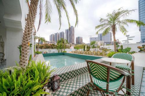 a patio with a table and chairs and a swimming pool at F-TOWN Fangtang Hotel (Shenzhen Longgang Tian'an Digital City Huanggekeng Subway Station) in Qinglinjing