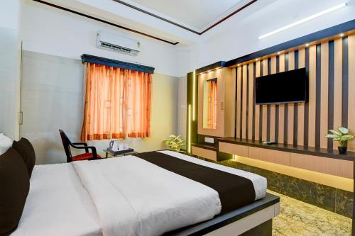 une chambre d'hôtel avec un lit et une télévision à écran plat dans l'établissement Super Hotel O Howrah Railway Station, à Salkhia