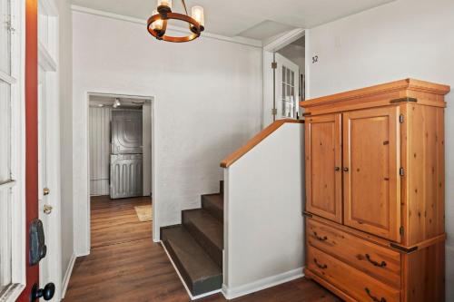 a hallway with a staircase and a wooden cabinet and a stair case at Timber Lodge #7 in Colorado Springs