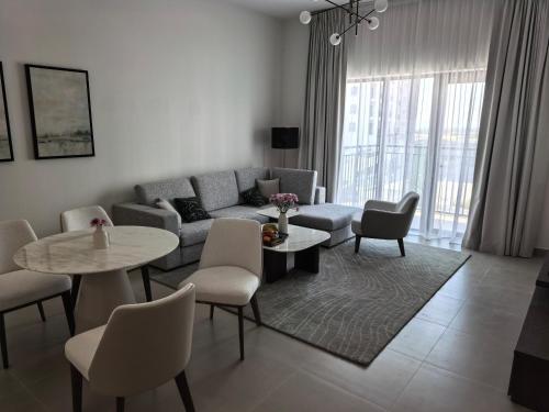 un salon avec un canapé, des tables et des chaises dans l'établissement Yas F1 1 bedroom apartment, à Abu Dhabi