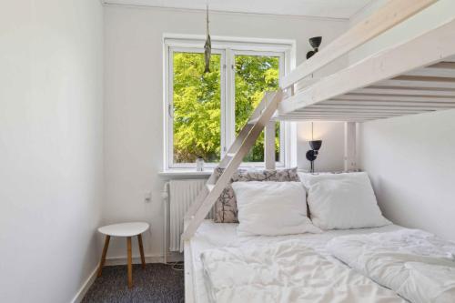 ein Schlafzimmer mit einem Bett mit weißen Laken und einer Leiter in der Unterkunft Holiday Home With Hot Tub Incl Final Ing in Fur