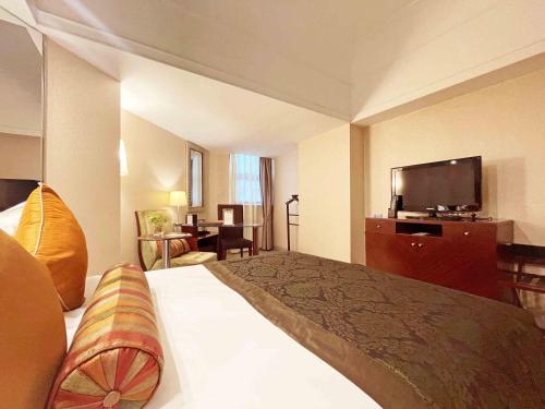 una habitación de hotel con cama y televisor de pantalla plana en Merry Hotel Shanghai (Former Rendezvous Merry Hotel Shanghai), en Shanghái