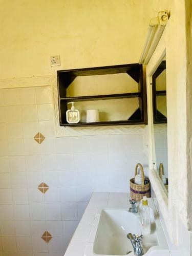 un bagno con lavandino e specchio di 3 bedroom own compound house a Malindi