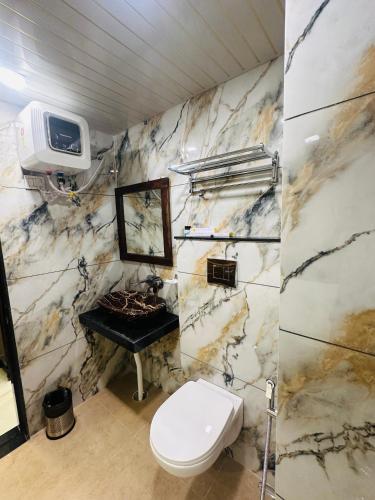 a bathroom with a toilet and a sink and a tv at MANGAL RESIDENCY Mountain View- A Luxury Boutique Business Hotel in Bedla