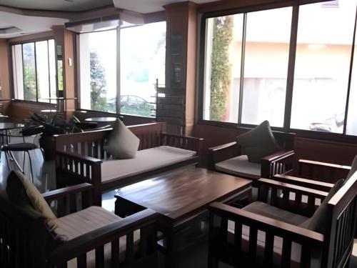 ein Restaurant mit Stühlen, einem Tisch und Fenstern in der Unterkunft SR Hotel in Ban Tha Kup