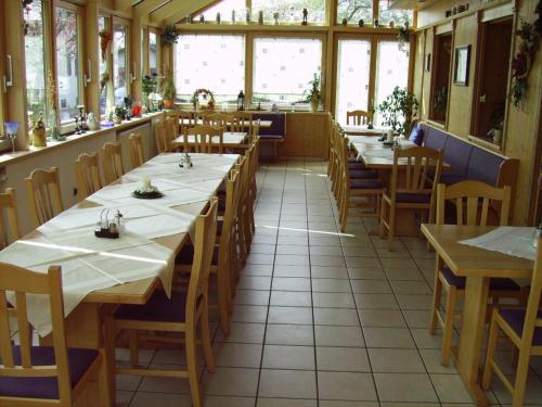 una sala da pranzo con tavoli e sedie in un ristorante di Reiterhof Gürster a Mitterfels