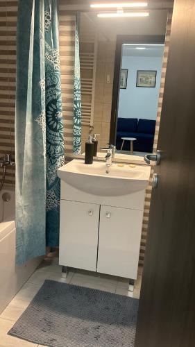 ein Badezimmer mit Waschbecken und Spiegel in der Unterkunft Kamu Military Residence Studio in Chiajna