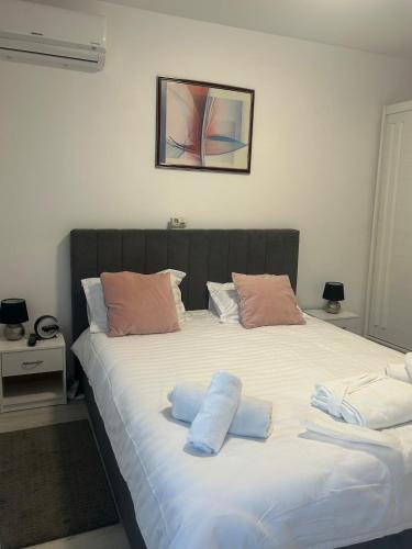 ein großes Bett mit zwei Kissen darauf in der Unterkunft Kamu Military Residence Studio in Chiajna