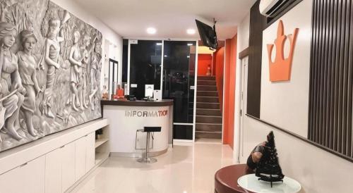 eine Lobby mit einer Wand mit einer Skulptur von Frauen in der Unterkunft The Loom Rangsit in Ban Lam Phak Kut