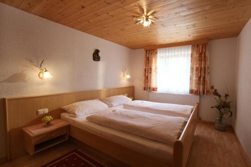 Kollerhof في إتيير: غرفة نوم بسرير وسقف خشبي
