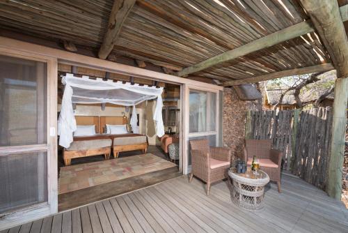a screened in porch with a bed and a canopy at Ongava Lodge in Okaukuejo
