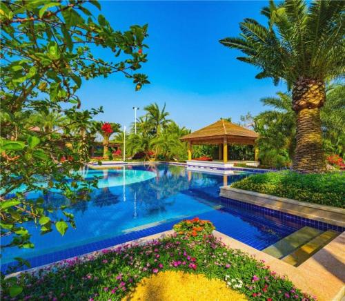 einen Pool mit einer Palme und einem Pavillon in der Unterkunft Country Garden Hot Spring Hotel Huizhou in Huizhou