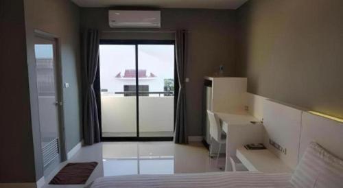 ein Schlafzimmer mit einem Bett und einem großen Fenster in der Unterkunft M-one Residence in Ban Kohong