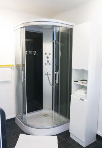 a shower with a glass door in a bathroom at Ferienhaus BLACK & WHITE in Bromberg