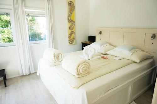 a bedroom with a white bed with towels on it at Ferienhaus BLACK & WHITE in Bromberg