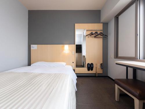 a bedroom with a white bed and a desk at Super Hotel Nara Shin Omiya Ekimae in Nara