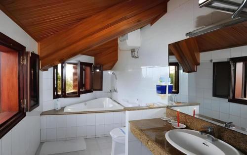 a bathroom with two sinks and a bath tub at Hai Au Hotel in Ðông Thôn