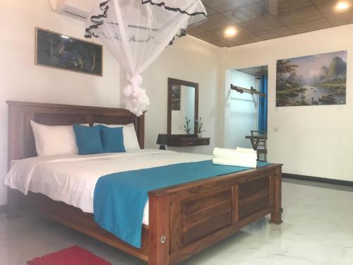 a bedroom with a bed with blue and white sheets at Yaluwa Tourist Rest & cooking class in Anuradhapura