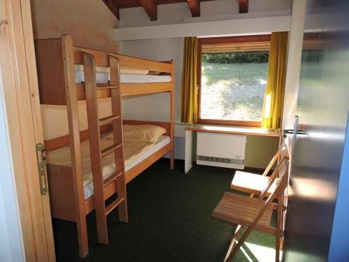 Zimmer mit 2 Etagenbetten und einem Fenster in der Unterkunft Feriendorf Tieringen in Meßstetten