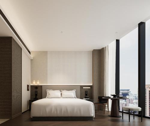 ein Schlafzimmer mit einem großen weißen Bett und großen Fenstern in der Unterkunft K SPACE Hotel - Guangzhou Beijing Road Pedestrian Street Dafo Ancient Temple Branch in Guangzhou