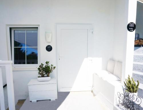 a white living room with a white couch and a window at Roomantic Apartments in Bromberg