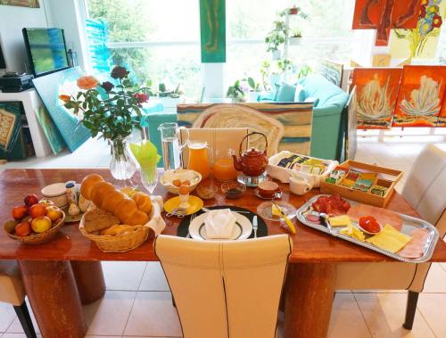 a wooden table with breakfast foods on it at Roomantic Apartments in Bromberg