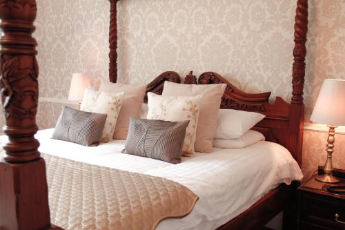 a bedroom with a bed with white sheets and pillows at Llechwen Hall in Pontypridd