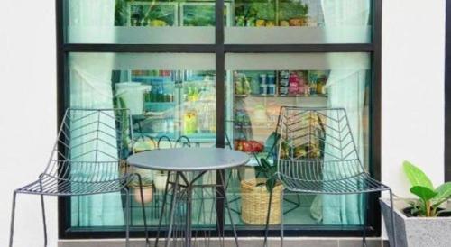 ein Tisch und Stühle vor einem Fenster in der Unterkunft The Hub Hotel Surin in Surin