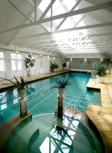 a large swimming pool with plants in a building at Fordoun Hotel and Spa in Nottingham Road