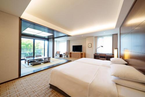 a bedroom with a large bed and a living room at Hyatt Regency Hakone Resort and Spa in Hakone