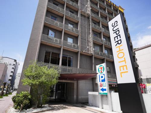 a building with a sign in front of it at Super Hotel Nara Shin Omiya Ekimae in Nara