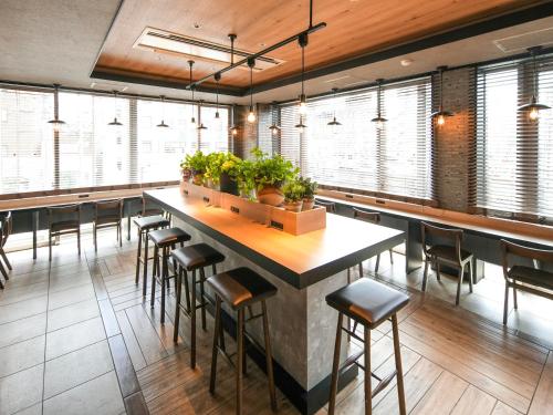 a restaurant with a large bar with stools at Super Hotel Nara Shin Omiya Ekimae in Nara