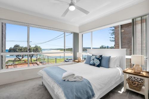 a bedroom with a bed and a large window at The Rotunda, Gerroa in Gerroa