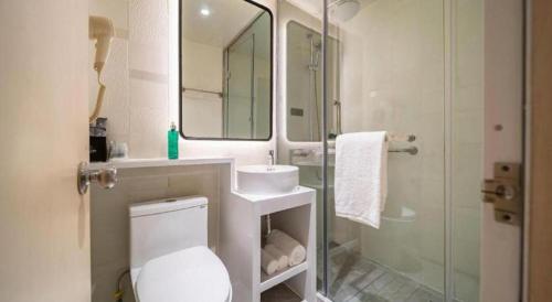 a bathroom with a toilet and a sink and a shower at Magnotel Business Xuzhou Jinying Sudi Road Metro Station in Xuzhou