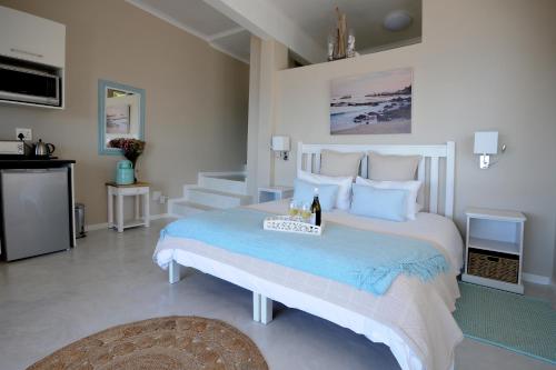 a bedroom with a large bed with a bottle of champagne at Rocklands Seaside Bed and Breakfast in Simonʼs Town