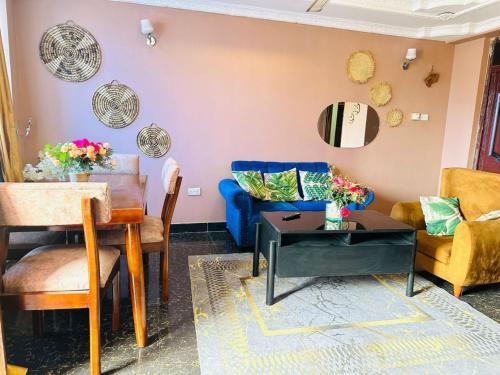 ein Wohnzimmer mit einem blauen Sofa und einem Tisch in der Unterkunft Exclusive 3BR City Escape High End Comfort & Stunning Views in Daressalam