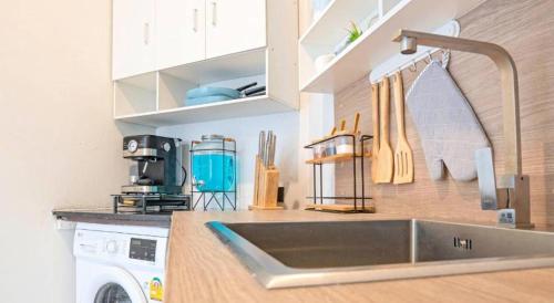 a kitchen with a sink and a washing machine at Chic Residences at Karon Beach in Karon Beach