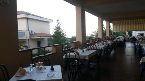 a restaurant with tables and chairs and a balcony at Hotel San Giorgio in San Nicola Arcella
