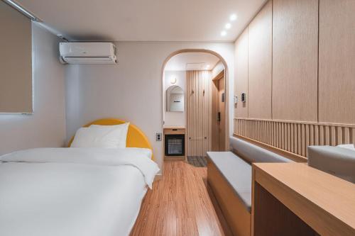 une petite chambre avec un lit et un lavabo dans l'établissement Gyeongju Hotel Gonggan, à Gyeongju