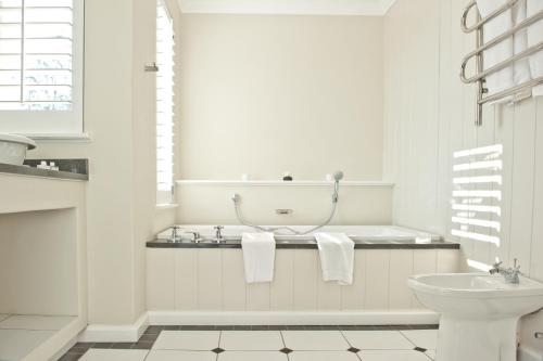a white bathroom with a tub and a toilet at Fordoun Hotel and Spa in Nottingham Road