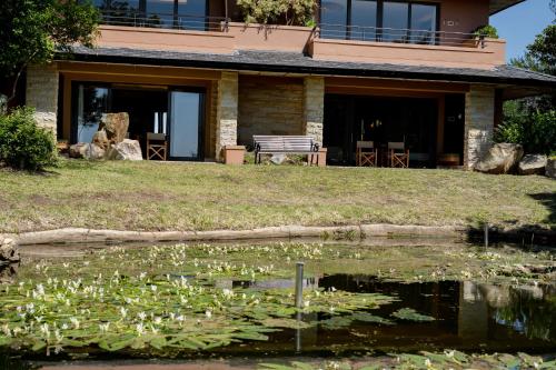 ein Haus mit einem Seerosenteich in der Unterkunft Pezula Nature Retreat in Knysna