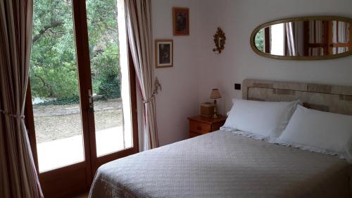 une chambre avec un lit et une grande fenêtre dans l'établissement La Pantoufle Verte, à Montauriol