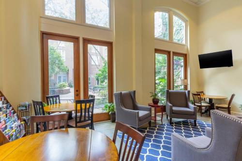 a restaurant with tables and chairs and windows at Church Street Inn Historic Charleston, Ascend Collection Hotel in Charleston